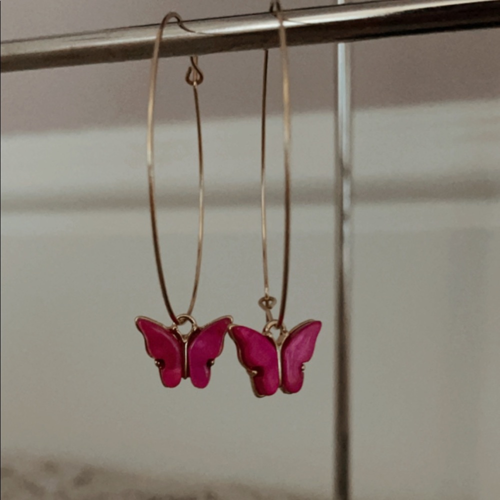 Medium gold hoop earrings with a pink butterfly
